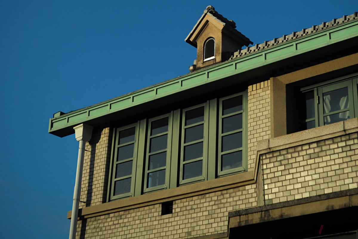 緑色のかわら屋根とタイル仕立ての外壁が印象的な「丸福樓」の外観