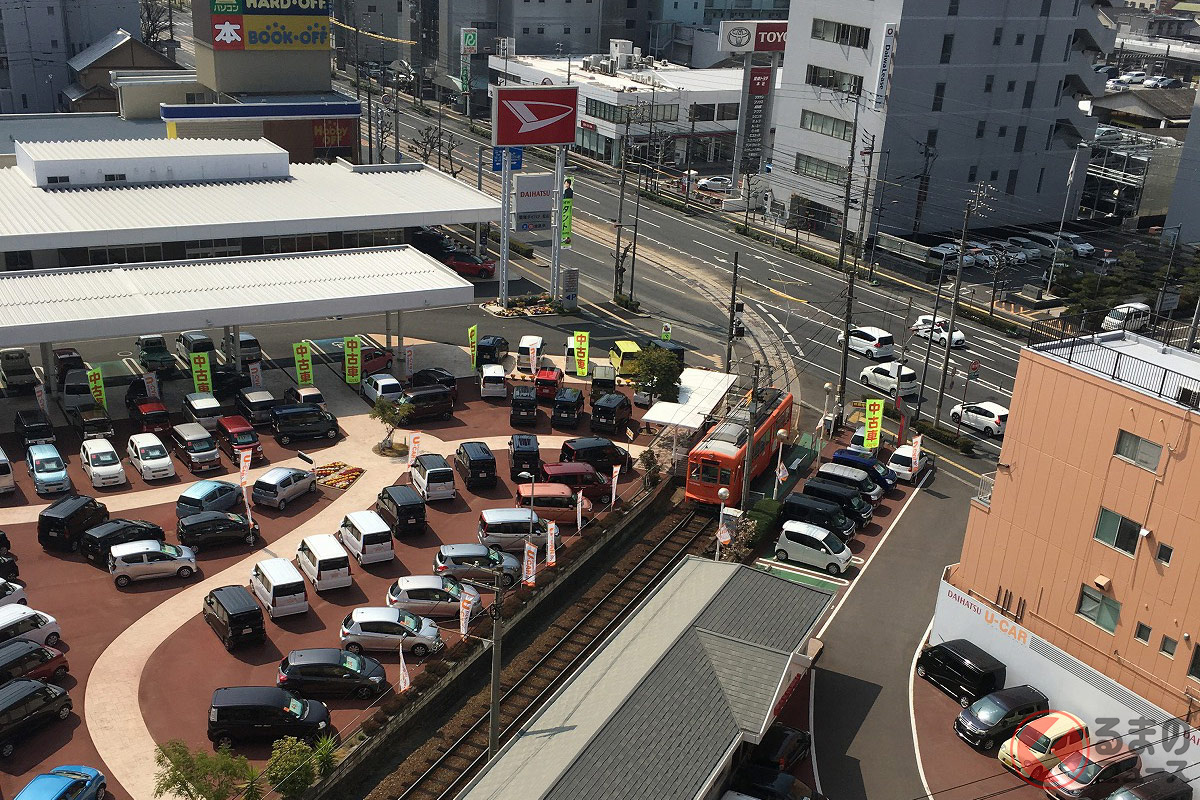 なぜダイハツ販売店に路面電車の駅が存在 摩訶不思議な光景の正体とは くるまのニュース