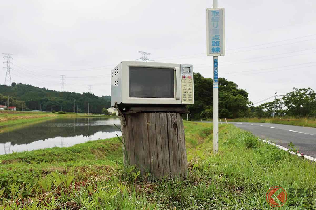 道端にたたずむ電子レンジと、「取締り重点路線」の標識(画像:オービスガイド)