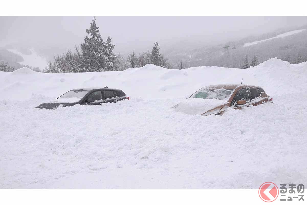 雪に埋もれたガソリン車(左)とEV(右)(画像:JAF)