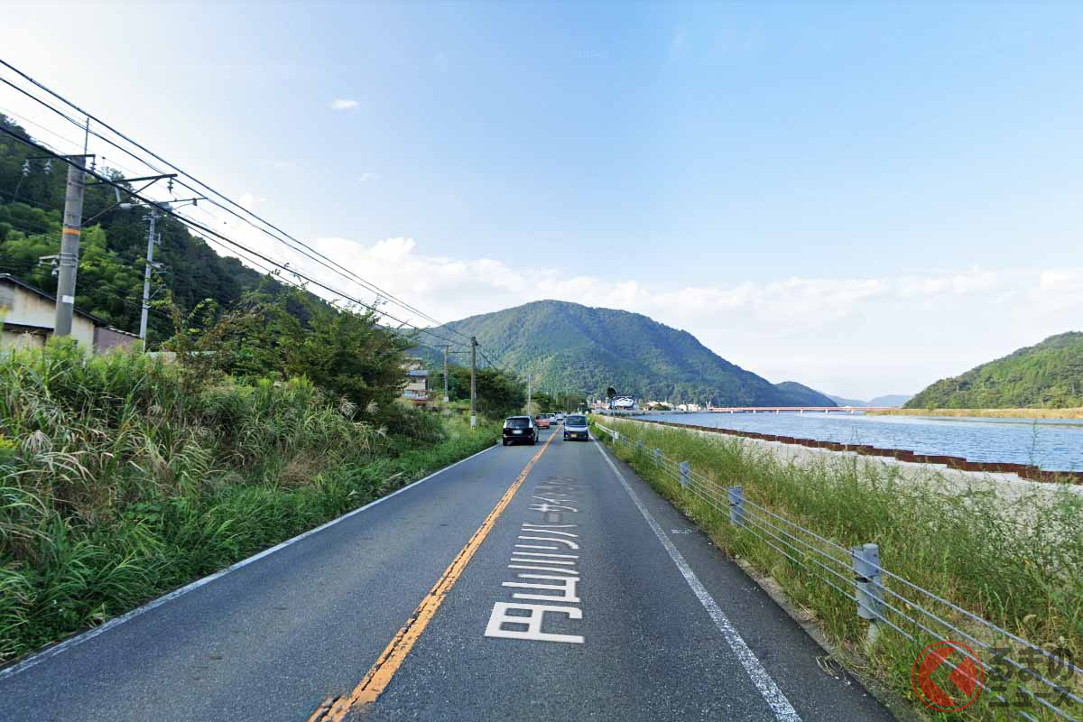 豊岡と城崎を結ぶ県道は、隣をほぼ同じ高さで円山川が流れ、反対側はJR山陰本線の列車が走る（(C) Google）