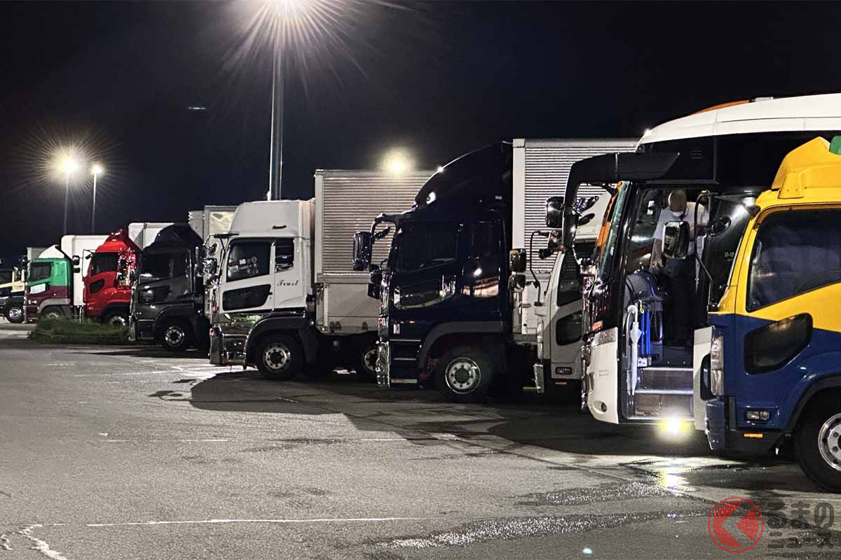 夜のSA駐車場に並ぶ大型車のイメージ（画像：写真AC）