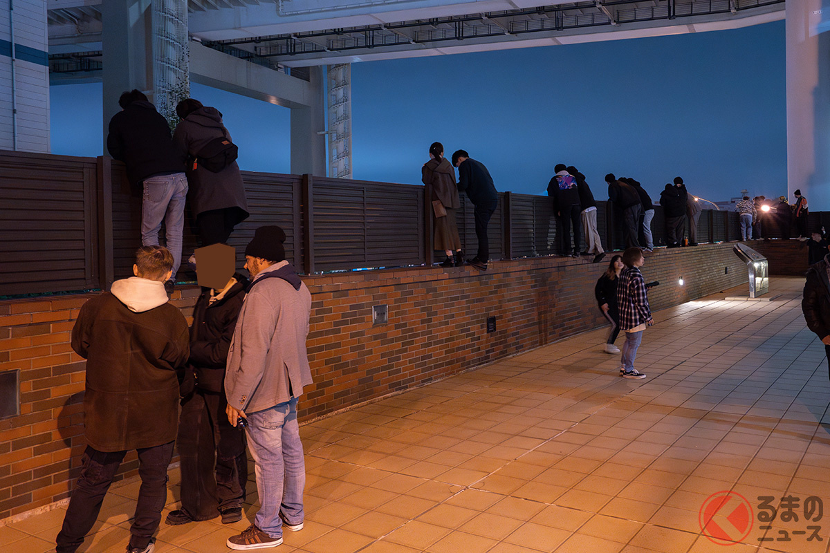 フェンスにのぼって見物するギャラリー(2023年12月上旬:筆者撮影)