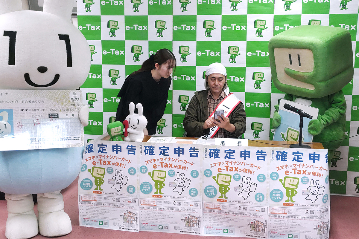 ヒロシの高級バイクどんなモデル？［画像はスマートフォンで確定申告の実演をする芸人のヒロシさん（右）／Photo：時事］