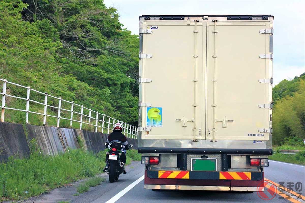 トラックの間をすり抜けるバイク(PhotoAC/うさみのん)