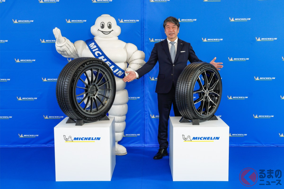 新製品「パイロットスポーツ 5 エナジー」(左)と「プライマシー 5 エナジー」(右)を披露する日本ミシュランタイヤの須藤元社長(右)とミシュランマン(左)