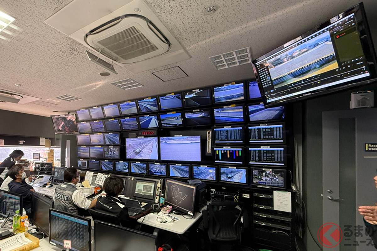 レースの管制室、様々な人がそれぞれの役割で業務を行っている