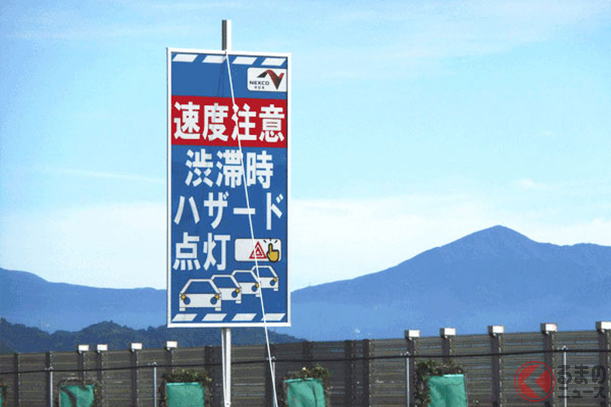 高速道路上に設置された、渋滞時のハザードランプ点灯と速度低下への注意を促す看板