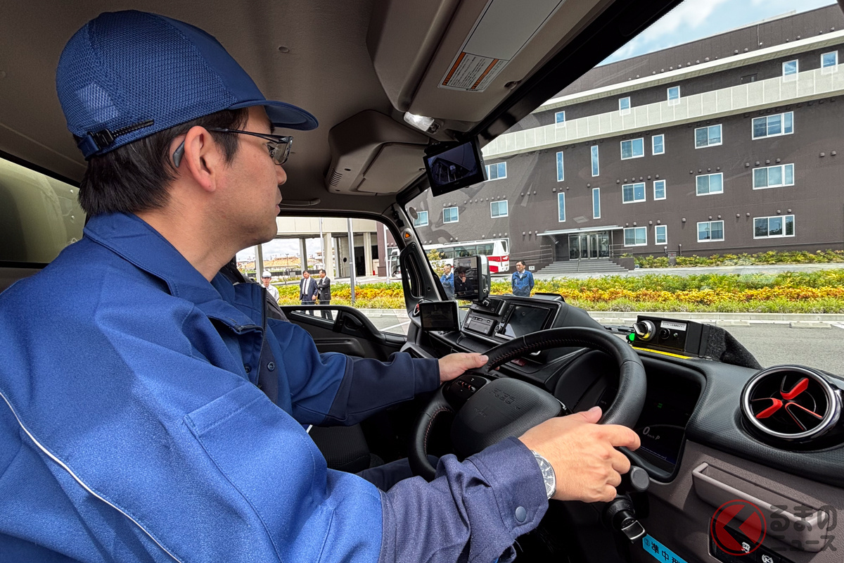 eCanterをワイヤレス充電するために駐車する名鉄NX運輸のドライバー。ワイヤレス充電は駐車の位置合わせが重要になるが、3段階の仕組みを導入することにより止めやすさを求めた