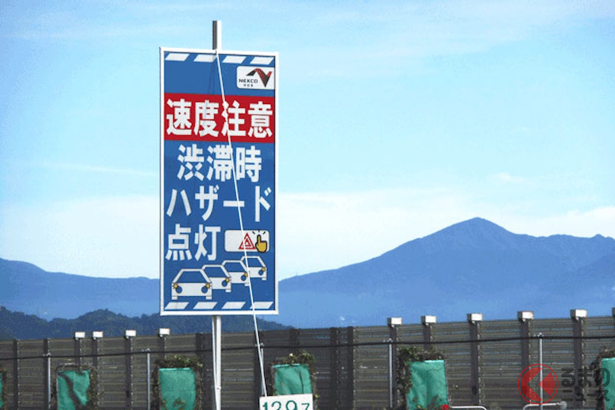 高速道路上に設置された、渋滞時のハザードランプ点灯と速度低下への注意を促す看板