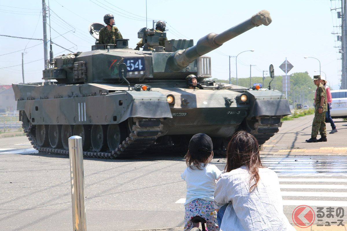 交差点を左折する90式戦車を見送る親子。地響きが伝わってくるが特に動じる様子もない。（画像：月刊PANZER編集部撮影）